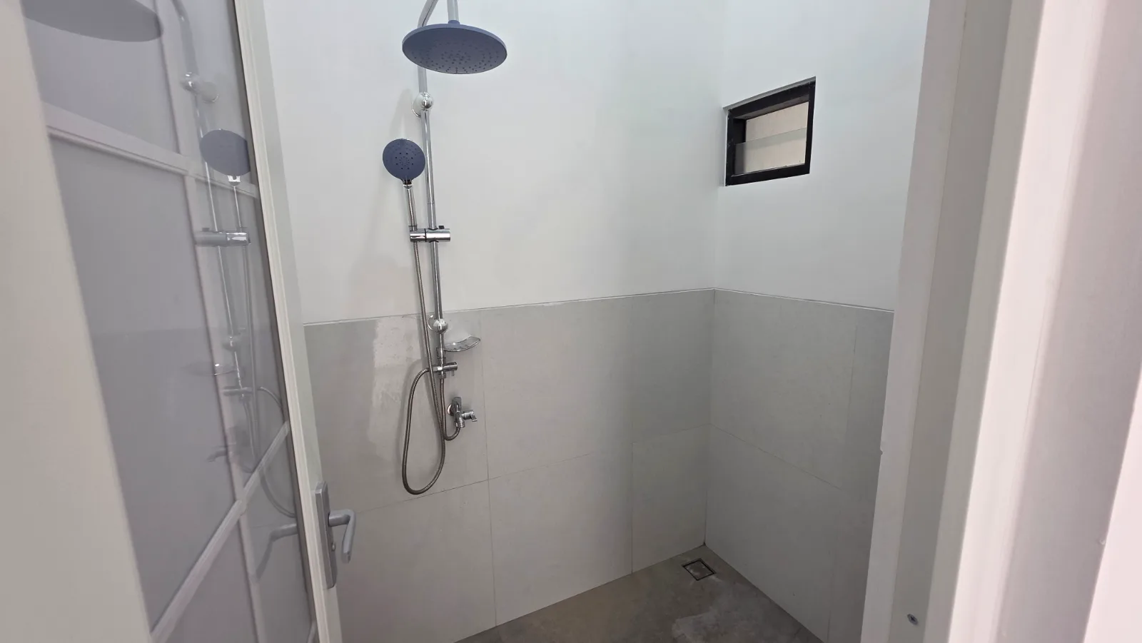 Kamar mandi modern — perpaduan keramik motif bata putih & granit abu.